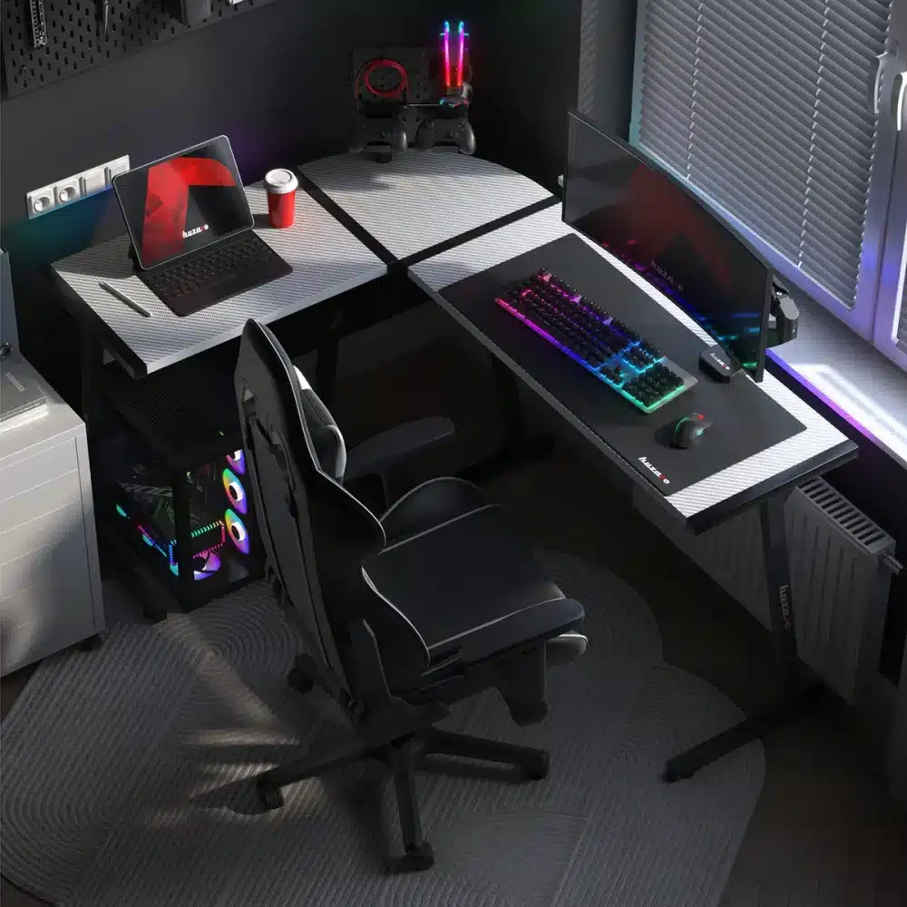 Radna stanica Huzaro Hero 6.0 pored prozora: tastatura i miš sa RGB osvetljenjem, zakrivljeni monitor i gejmerska stolica